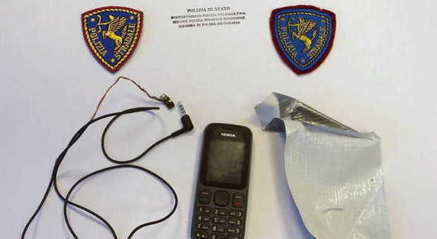 Il telefonino e l'auricolare sequestrato al cittadino straniero (foto Polizia stradale)