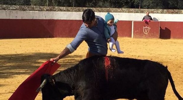 Sfida il toro con la figlia di 5 mesi in braccio: sui social network le critiche al torero