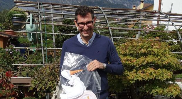 Un sorridente Fabio Dal Zotto con in mano la cicogna che annunciava la nascita della sua bambina