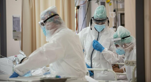 Operatori sanitari al lavoro nella terapia intensiva con tute protettive mediche e mascherine