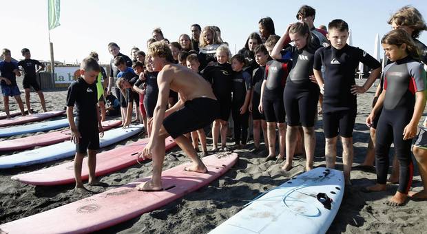 Una lezione di surf del campione Leonardo Fioravanti ai bambini della Fondazione Laureus sul litorale di Ostia
