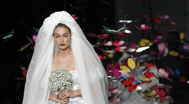 Gigi Hadid sfila per Moschino a Milano, l'abito da sposa ha lo strascico di farfalle