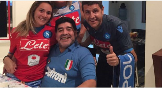 Maradona con la maglia dello scudetto segue la partita in tv da Dubai