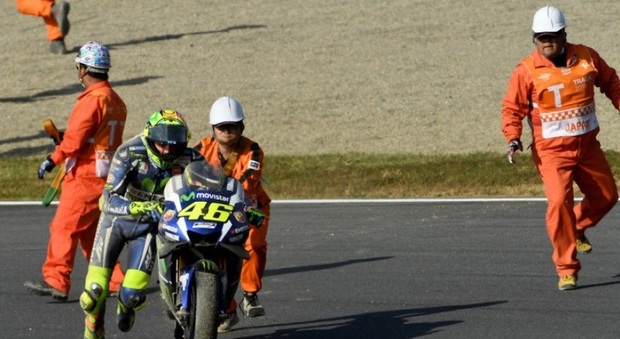 Valentino Rossi spinge la sua Yamaha dopo la caduta a Motegi