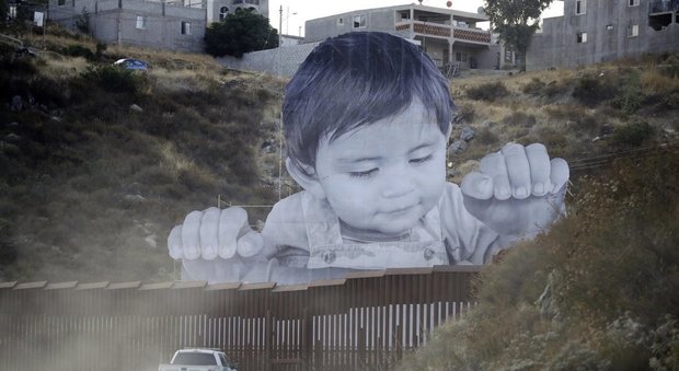 Confine Messico-Usa, un bimbo gigantesco spunta sul muro della discordia