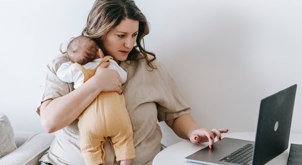 Una donna lavora in smart working mentre accudisce suo figlio