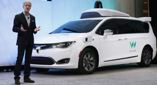 John Krafick, il numero uno di Waymo, la divisione auto autonome di Google a fianco di una Chrysler Pacifica a Detroit