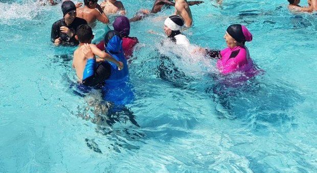 Donne musulmane in piscina col burkini per protesta contro il divieto: multate