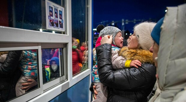 Un bimbo ucraino piange tra le braccia della madre
