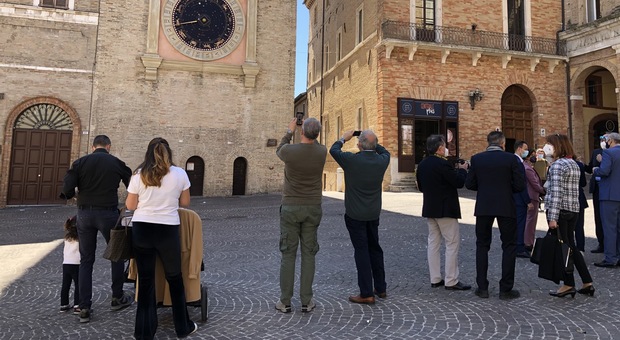 I turisti in piazza della Libertà fotografano l’orologio astronomico