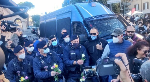 Gli agenti con le rose regalate dalle manifestanti (foto Twitter Giordano Giusti)