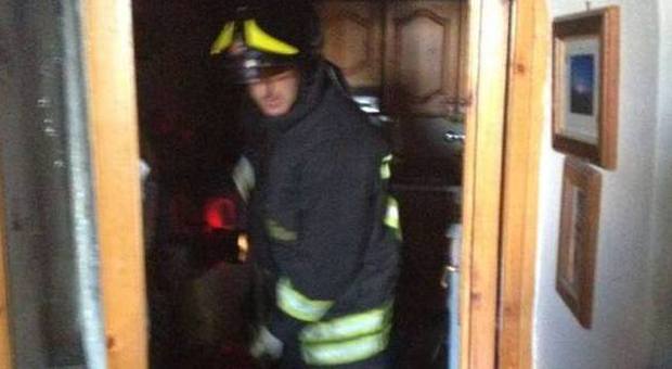 pompiere in azione all'interno dell'appartamento semidistrutto dall'incendio