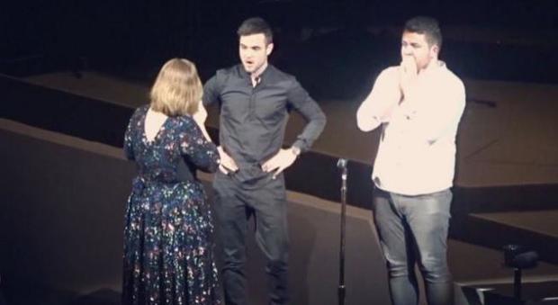 Adele sul palco con i suoi due giovani fan