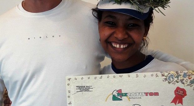 Gennet Tufa sorridente con il diploma da pizzaiola