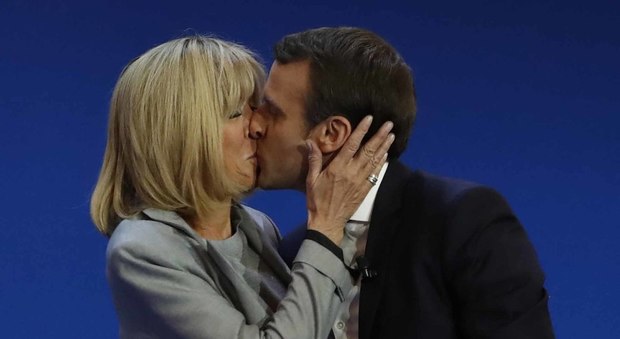 Macron verso l'Eliseo, bacio sul palco La moglie è di 25 anni più grande Ritratto tra pubblico e privato