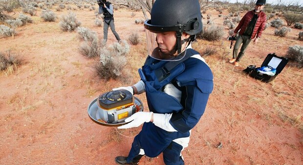 Un ricercatore dell'Agenzia spaziale giapponese raccoglie la capsula contenente il prezioso materiale
