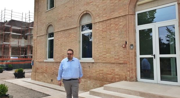 Il sindaco Davide Dellonti davanti alla scuola dell'infanzia e sulla sinistra il cantiere della primaria