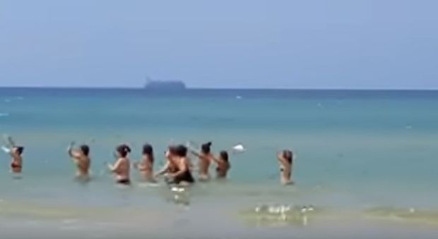 Balli in spiaggia a Pozzallo, sullo sfondo la Maersk con 108 migranti in attesa: il video scatena le polemiche