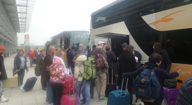 I passeggeri salgono sui bus dopo la cancellazione del volo per Londra