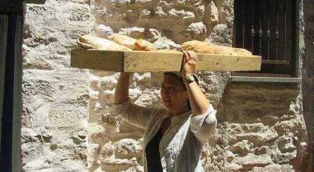 Una delle donne di Messenano con il pane appena sfornato
