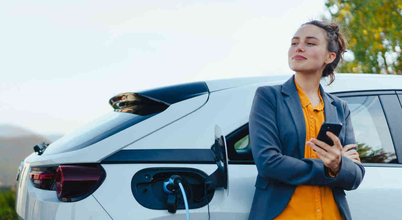 Una giovane automobilista ricarica la sua auto elettrica