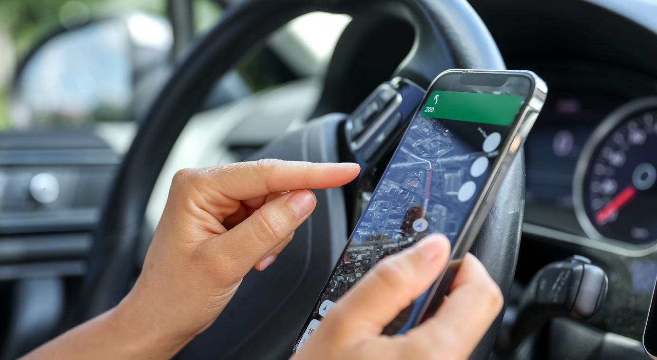 https://statics.cedscdn.it/photos/MED_HIGH/2025/06/24/8916866_24082603_female_driver_hand_holding_phone_with_interface_navigator_screen.jpg