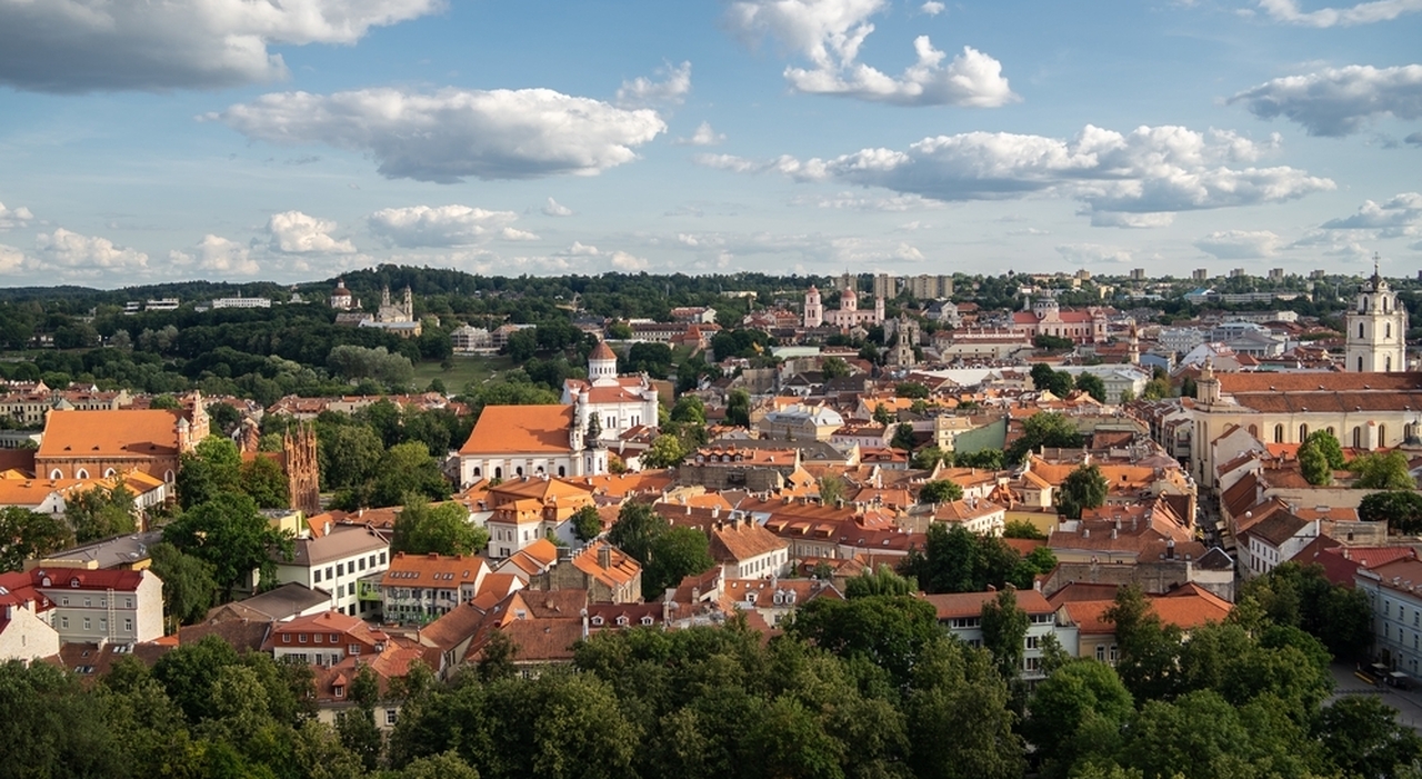 https://statics.cedscdn.it/photos/MED_HIGH/2025/07/03/8935650_03173432_citta_di_vilnius_circondata_da_edifici_e_vegetazione_sotto_la_luce_del_sole_e_un_cielo_nuvoloso_lituania_1_1_.jpg