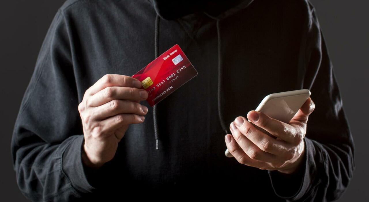 https://statics.cedscdn.it/photos/MED_HIGH/2026/06/22/9607665_22143142_front_view_male_hacker_holding_smartphone_credit_card.jpg
