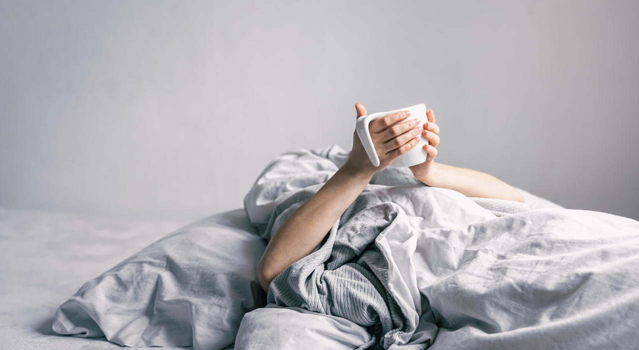 https://statics.cedscdn.it/photos/MED_HIGH/2026/07/08/9639406_08142451_womans_hand_holds_cup_coffee_while_lying_bed.jpg