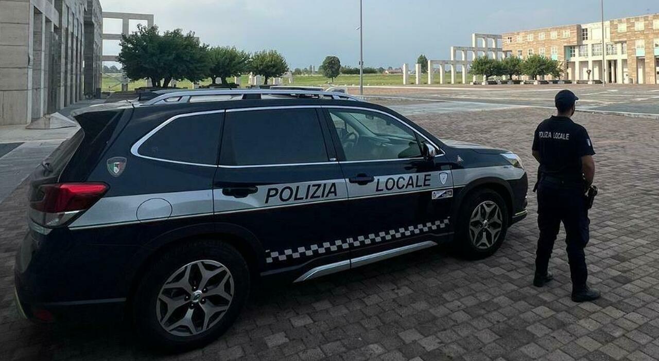 Un uomo parla con agenti di polizia in uniforme, mentre uno schermo mostra commenti sui social media
