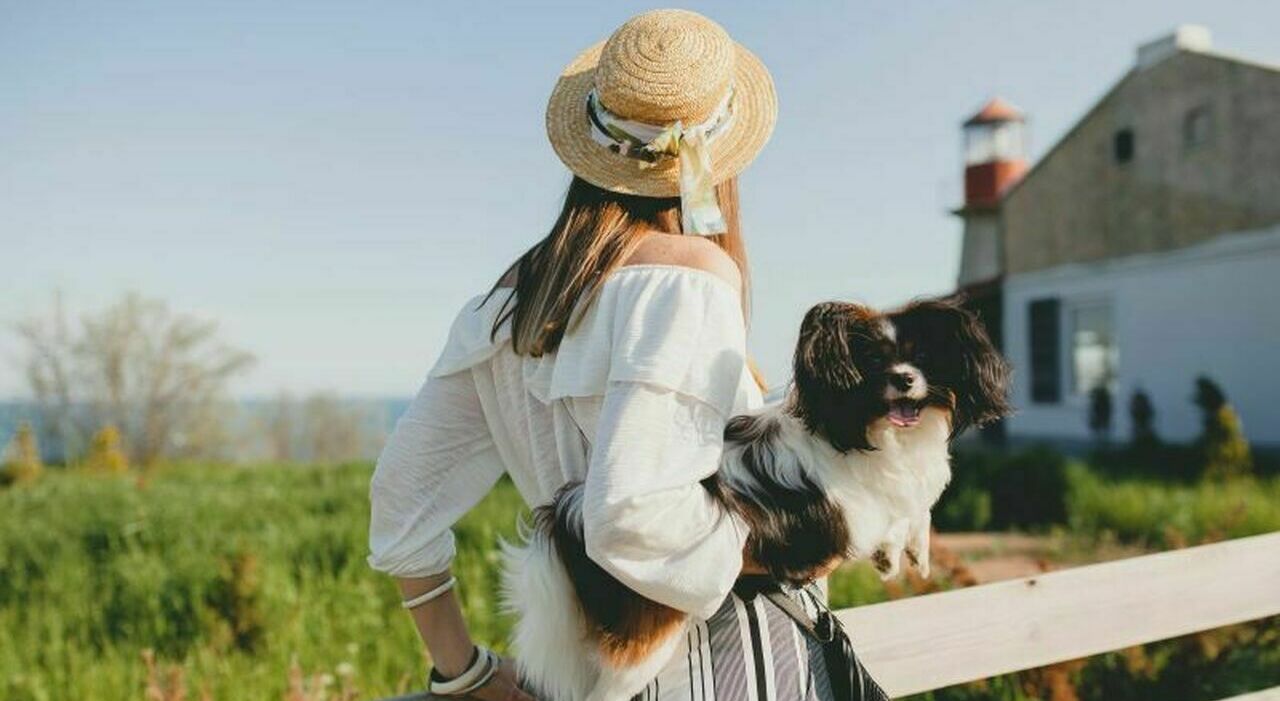 https://statics.cedscdn.it/photos/MED_HIGH/2026/08/03/9688280_03165831_9486776_21165643_view_from_back_stylish_woman_countryside_holding_dog_happy_positive_mood_summer_straw_hat_bohemian_style_outfit_1_.jpg
