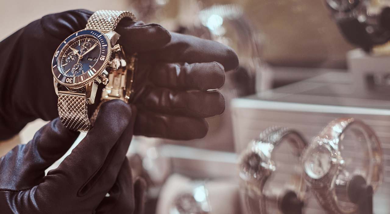 https://statics.cedscdn.it/photos/MED_HIGH/2026/08/17/9711207_17131143_close_up_seller_s_hands_gloves_shows_exclusive_men_s_watch_from_new_collection_luxury_jewelry_store.jpg