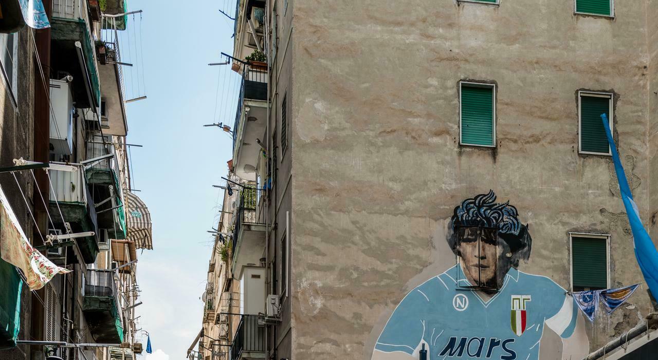 Turisti di tutto il mondo si radunano intorno al murale di Maradona a Napoli, in attesa del restauro