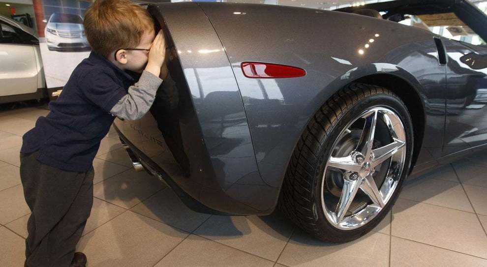 Un bambino affascinato dalle auto in un concessionario