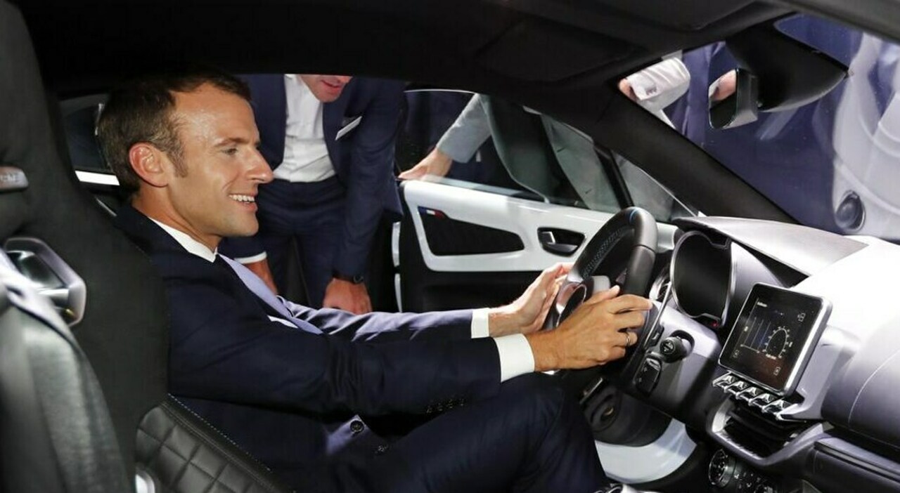 Il presidente Macron a bordo di un veicolo elettrico durante un salone dell'auto