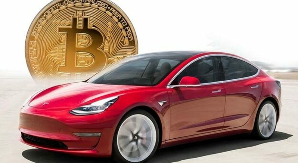Una Tesla conalle spalle il simbolo dei bitcoin