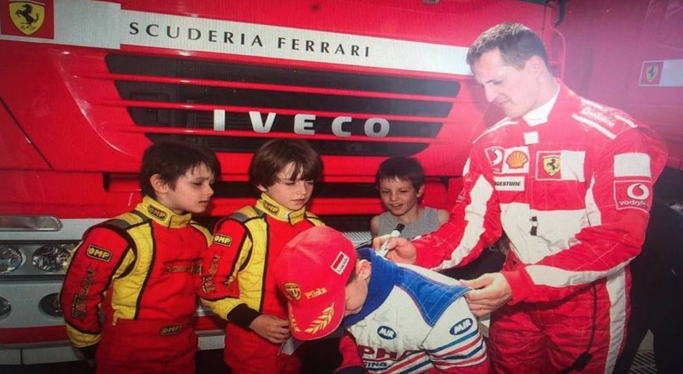 Michael Schumacher mentre firma le tute dei piccoli piloti di kart tra cui un giovanissimo Charles Leclerc