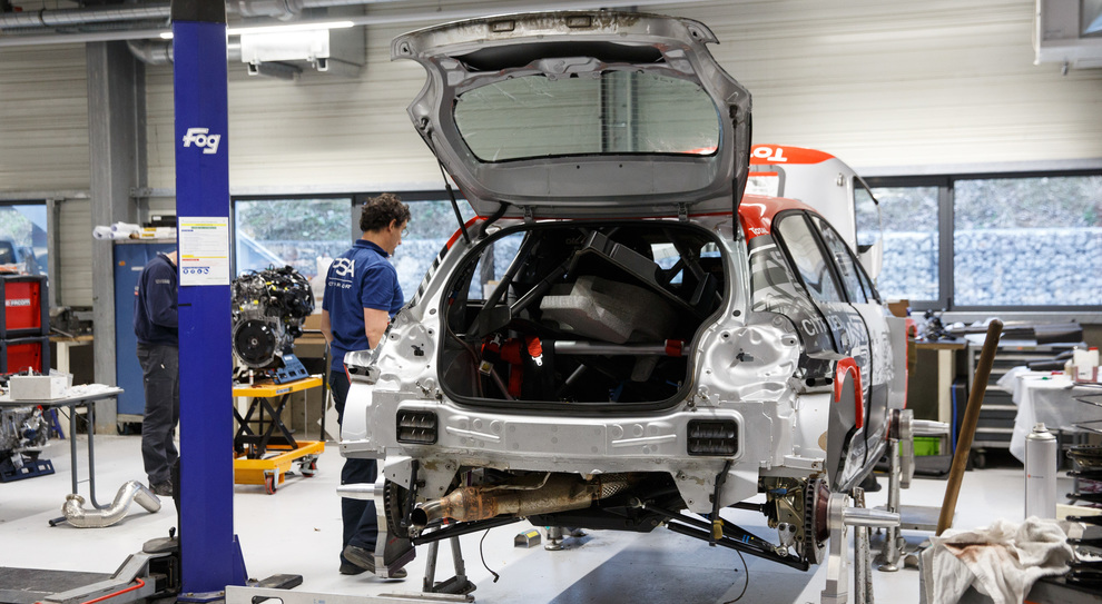 Un meccanico al lavoro su una C3 WRC nella fabbrica di Citroen Racing a Satory
