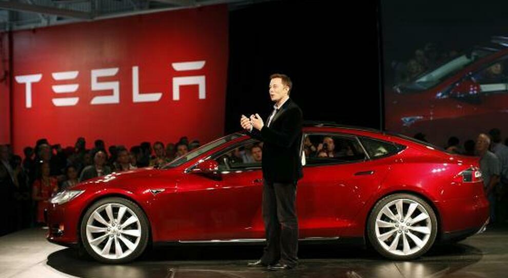 Elon Musk con uno dei suoi modelli Tesla