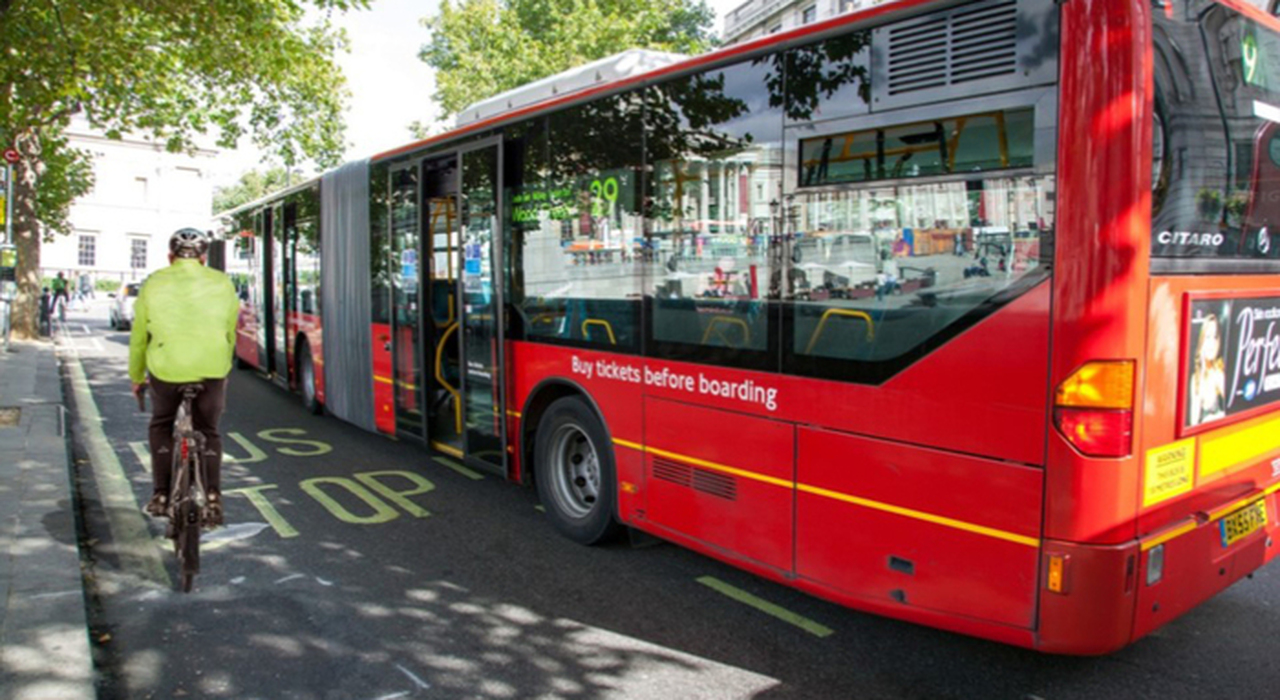 Un ciclista ed un autobus in Gran Bretagna. Con il nuovo codice della strada il ciclista sarà più tutelato