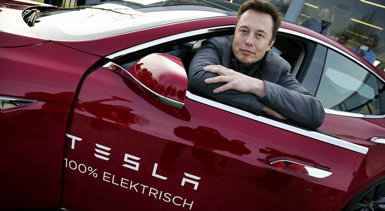 Elon Musk, fondatore di Tesla su uno dei suoi modelli