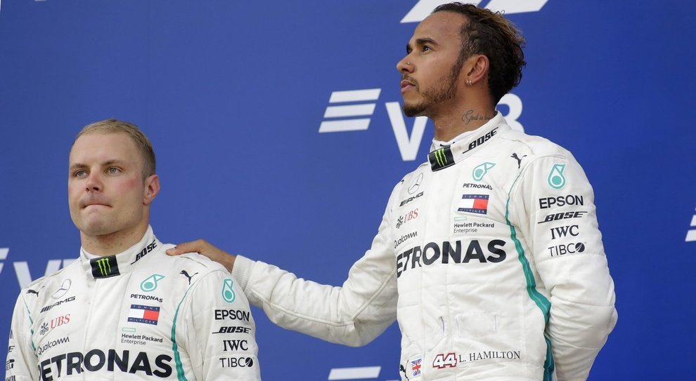 Lewis Hamilton festeggia consolando il compagno di squadra Bottas costretto a lasciargli la vittoria dal team