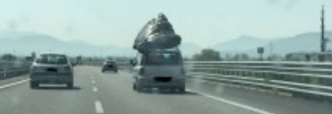 Materasso matrimoniale
sul tettuccio dell'auto
Famiglia fermata in autostrada