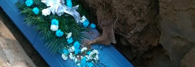 Choc durante la sepoltura: una gamba affiora dalla terra e si appoggia sulla bara del defunto /Foto