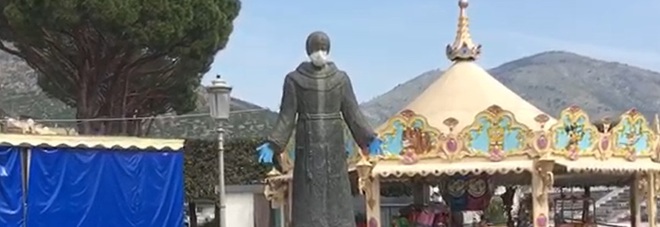 La statua di San Francesco con guanti e mascherina