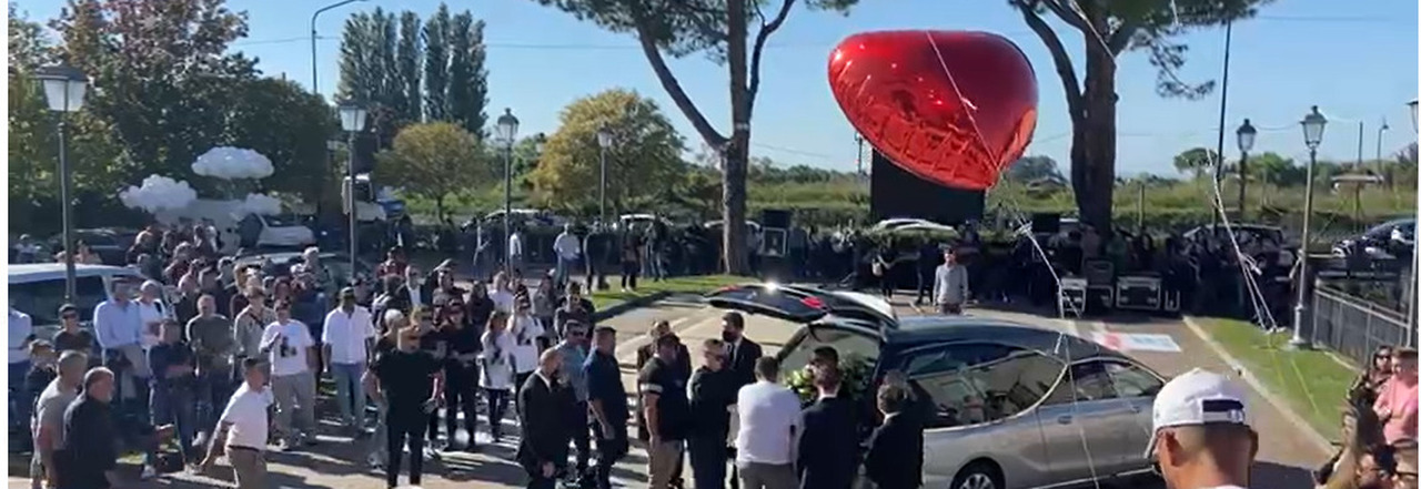 Nuvola di palloncini rossi e centinaia di persone al funerale di