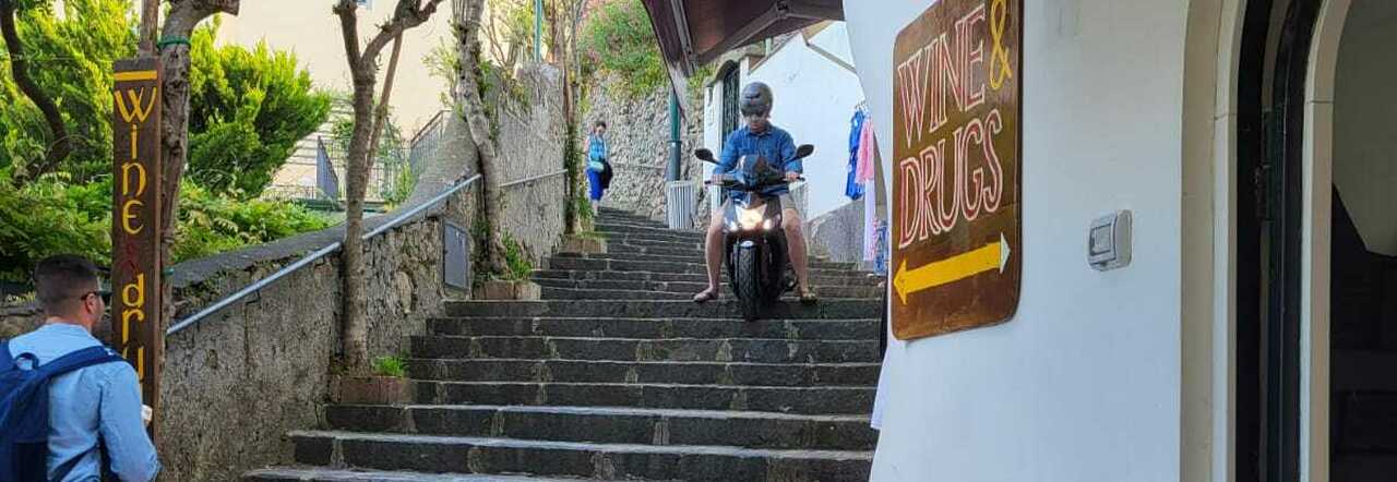 Turista scende le scale con lo scooter a noleggio