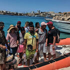 Migranti, sbarca a Lampedua con il barboncino al guinzaglio: «Cerchiamo lavoro e libertà»