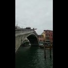 Incredibile a Venezia: turista si tuffa dal ponte con la tavola da surf