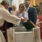 Neonata interrompe il battesimo e lancia la Bibbia nell'acqua santa: la reazione choc dei genitori VIDEO